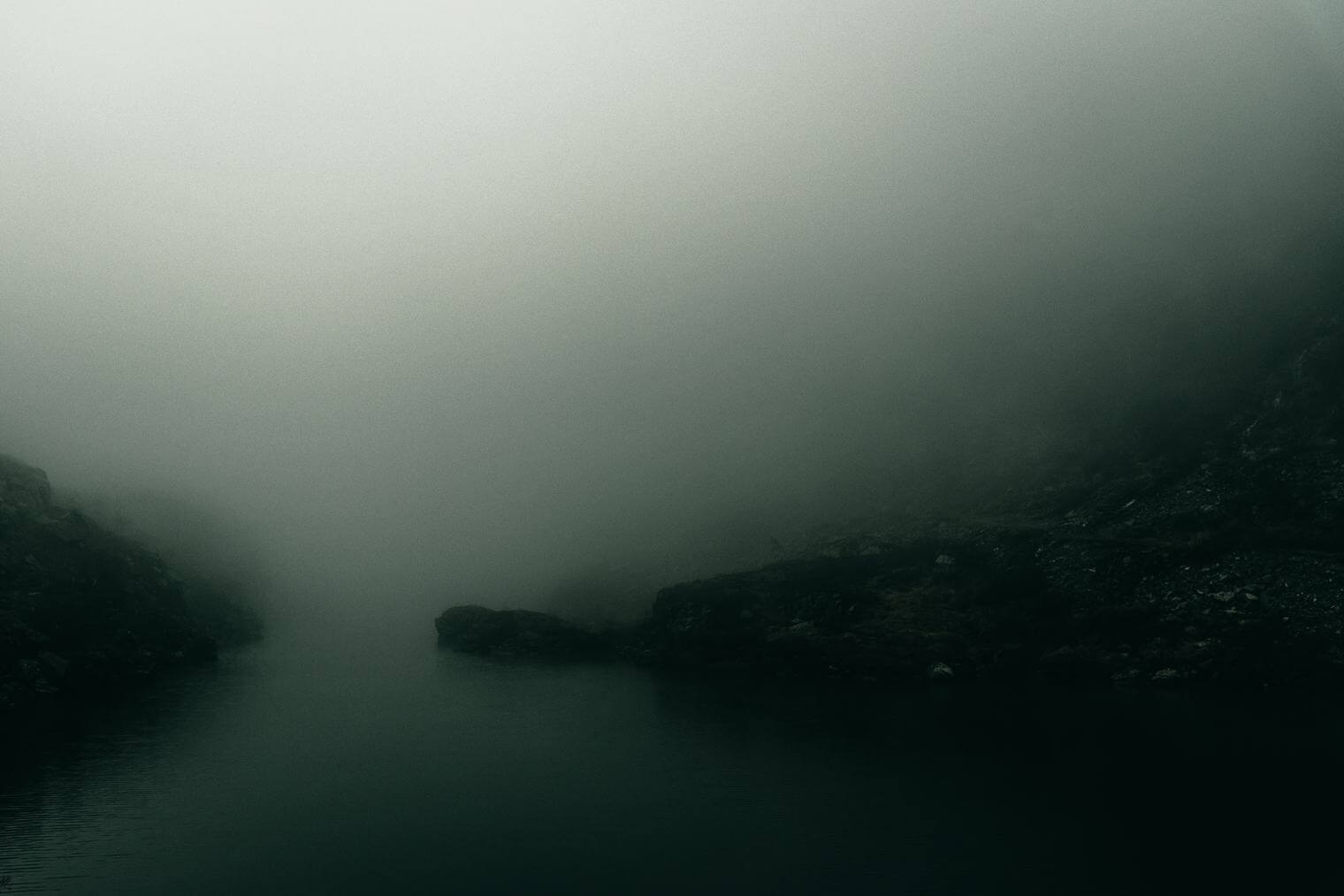 Dark landscape with fog and lake