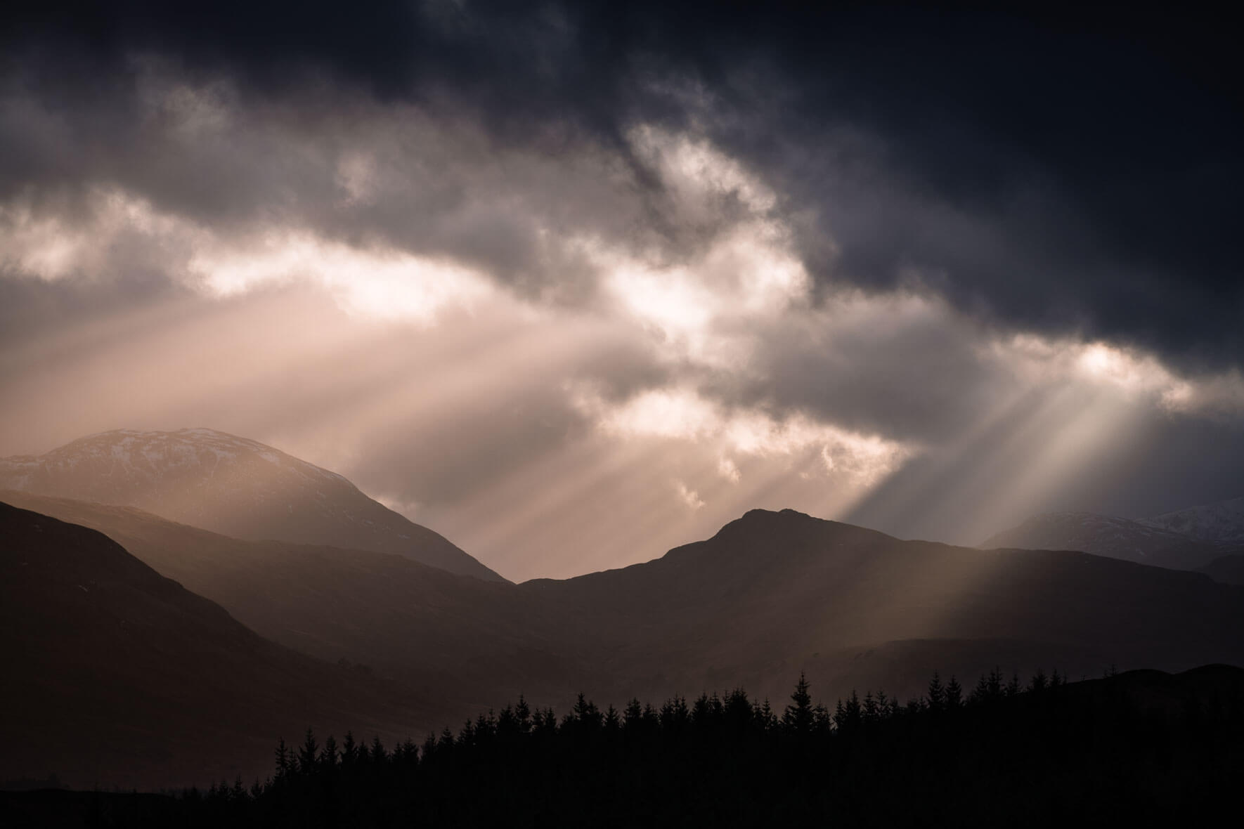 Sun breaking through the clouds over Glencoe, Scotland