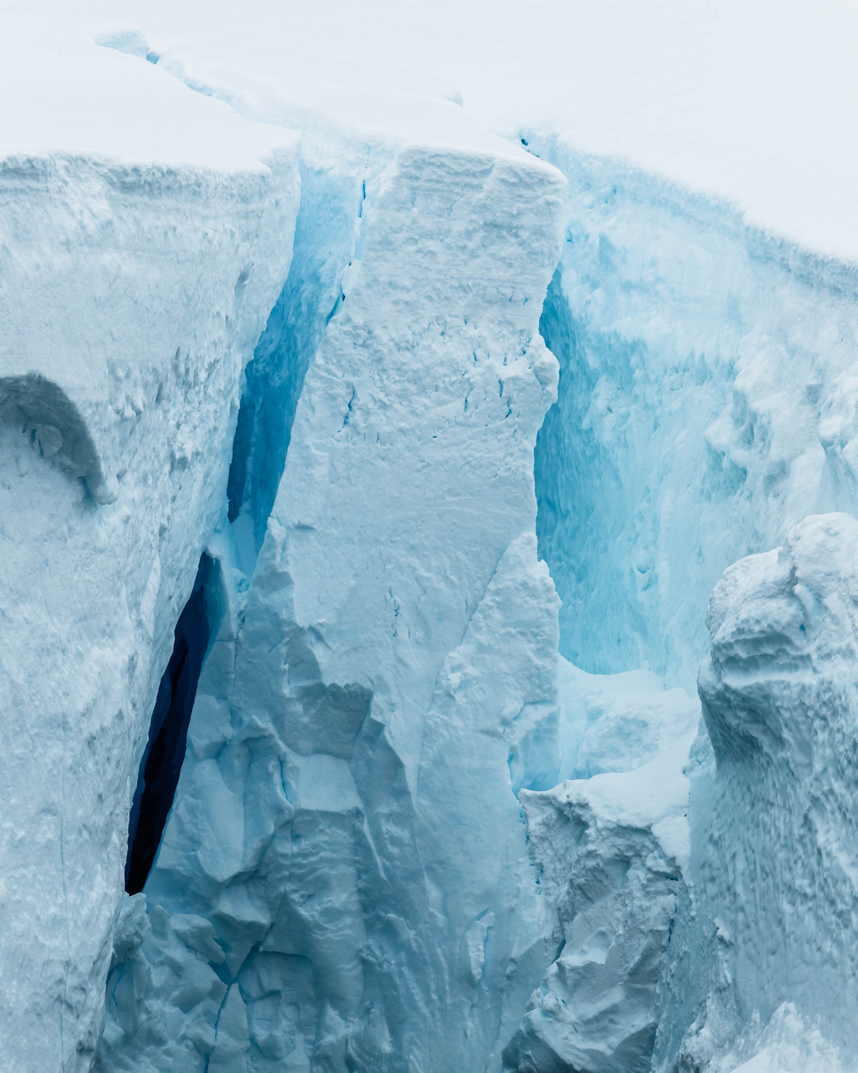 Blue glow inside a glacier crevasse of Antarctica