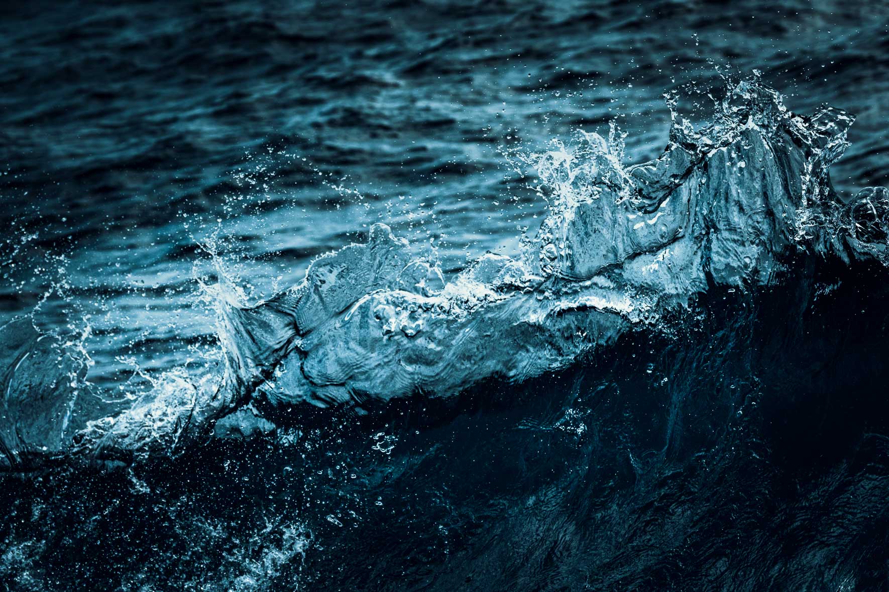 Abstract photography of breaking wave in monochrome blue