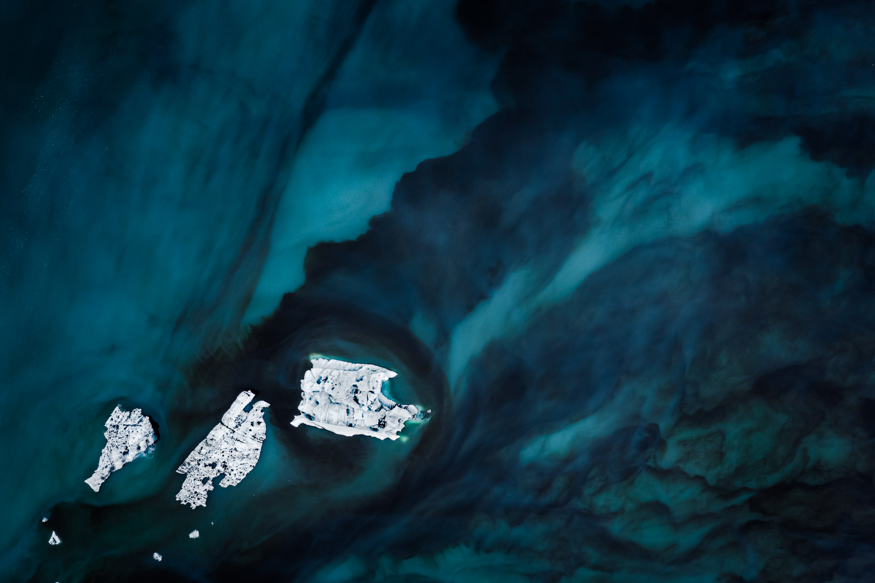 Aerial photography of icebergs floating in a dark glacier lagoon