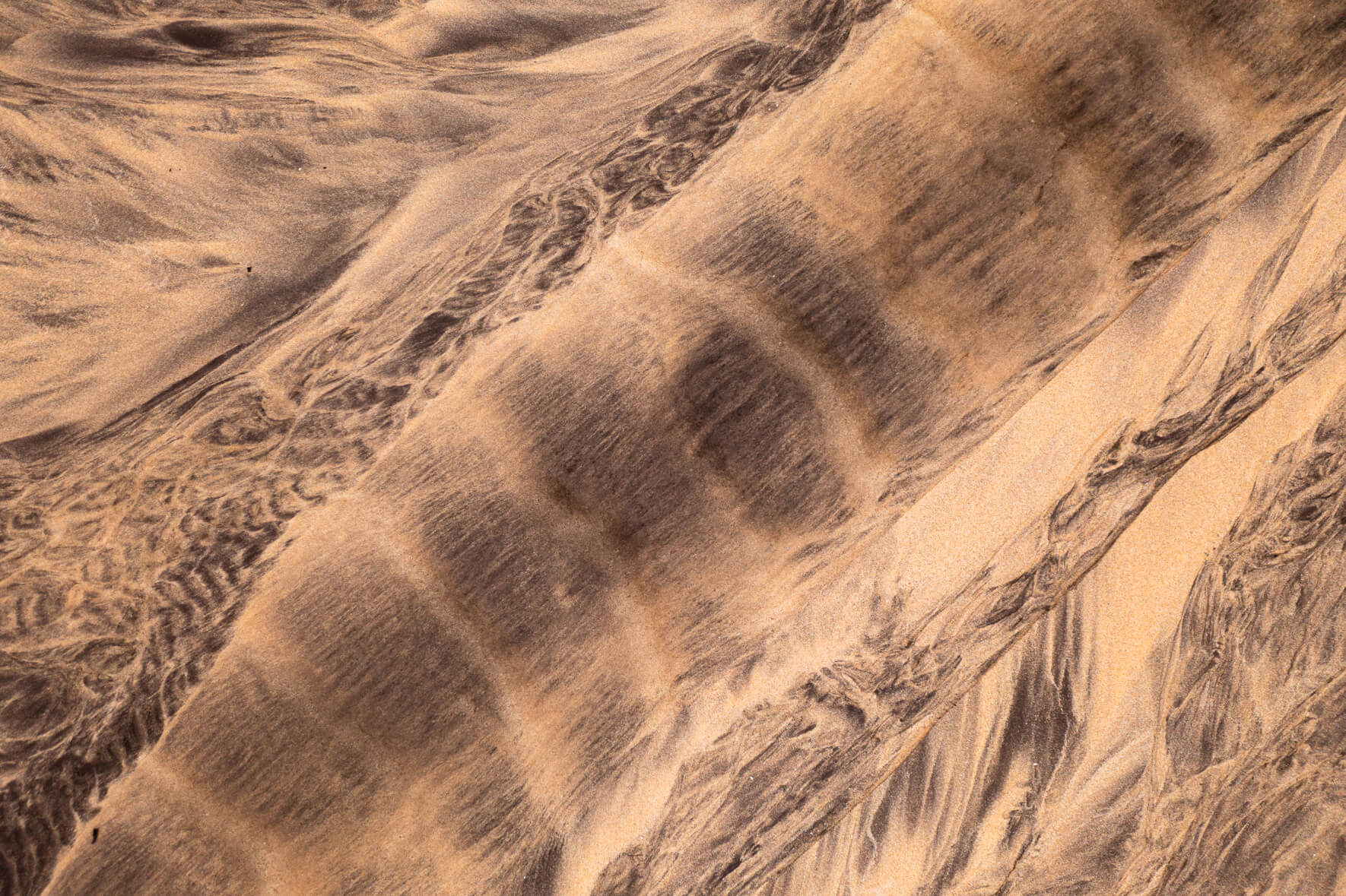 Aerial view of a creek running over a beach in the Westfjords of Iceland