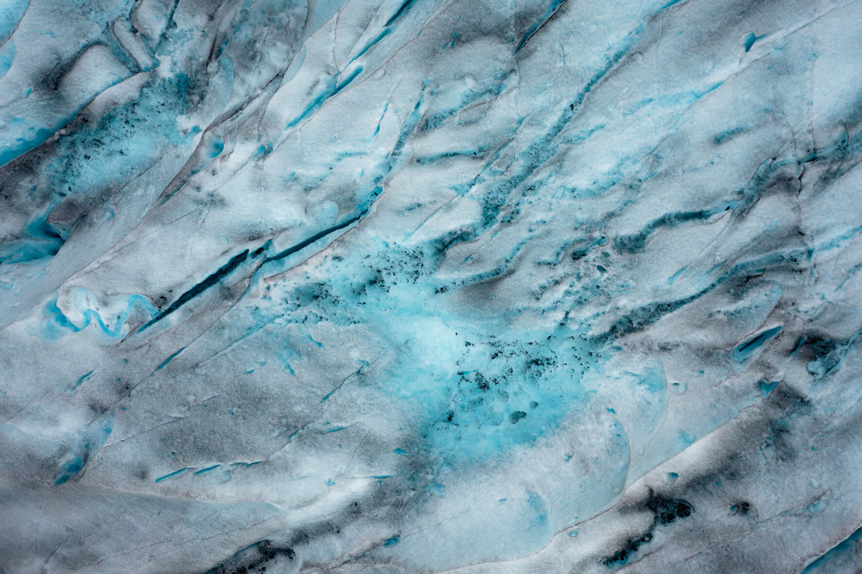 Meltwater lakes with rocks and sand on top of Jostedalsbreen glacier in Norway