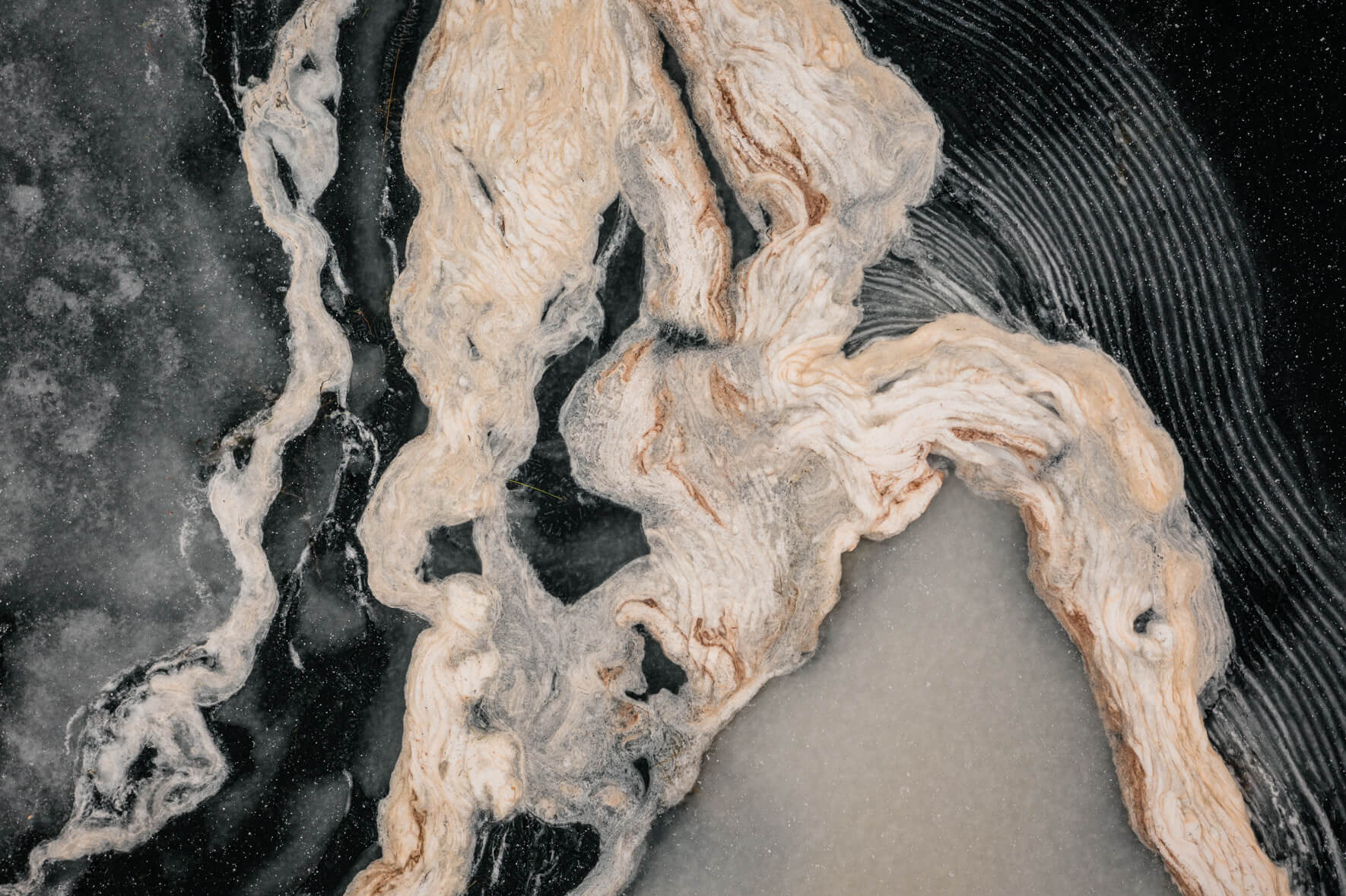 Drone view of a frozen lake in Norway with abstract textures and patterns on the ice surface