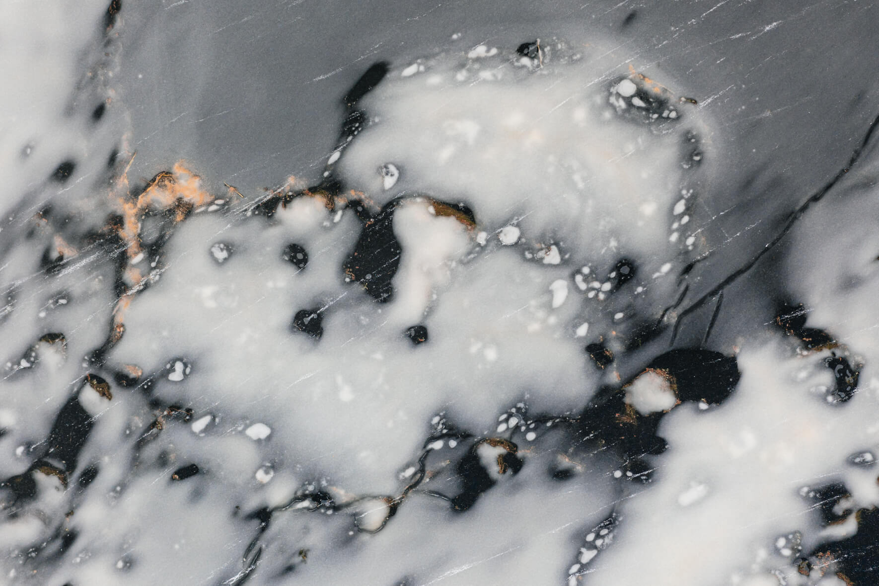 Aerial view of a frozen lake in Norway with abstract patterns and small ice floes on the ice surface