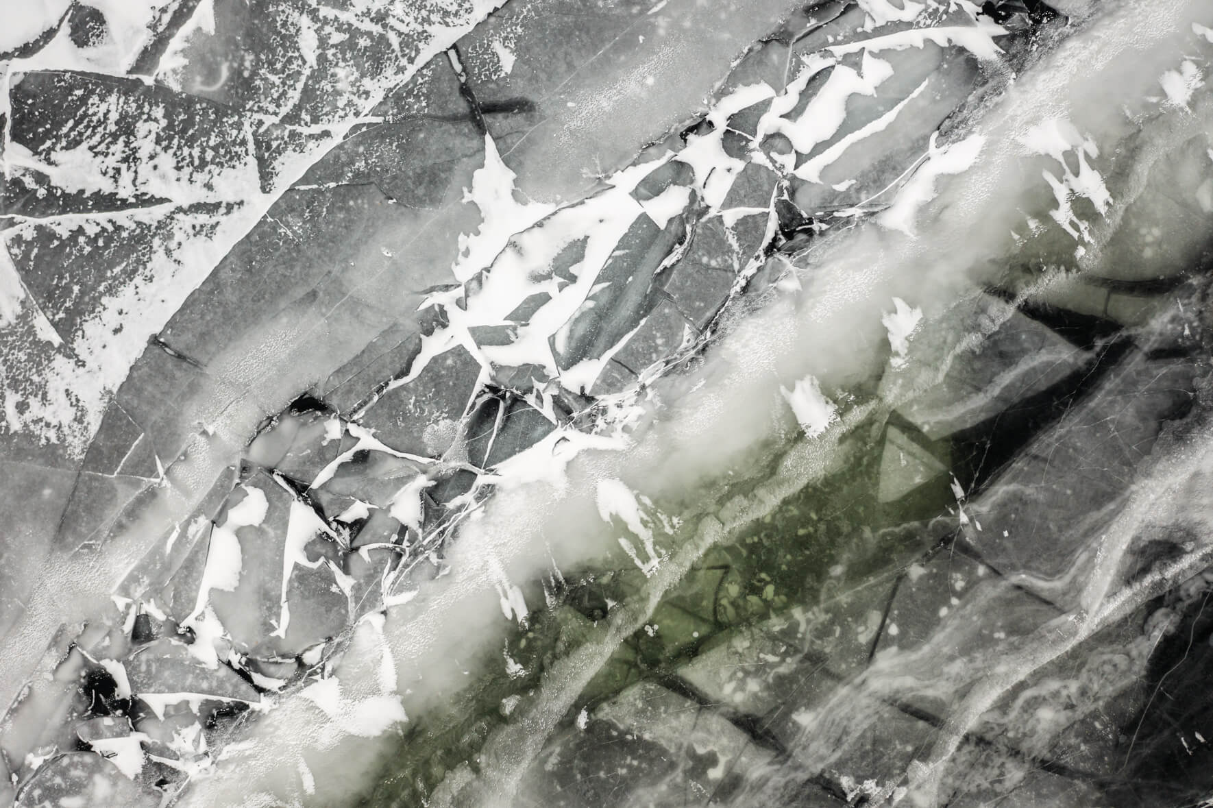 Aerial view of frozen lake in Norway with colorful and abstract textures and ice floes