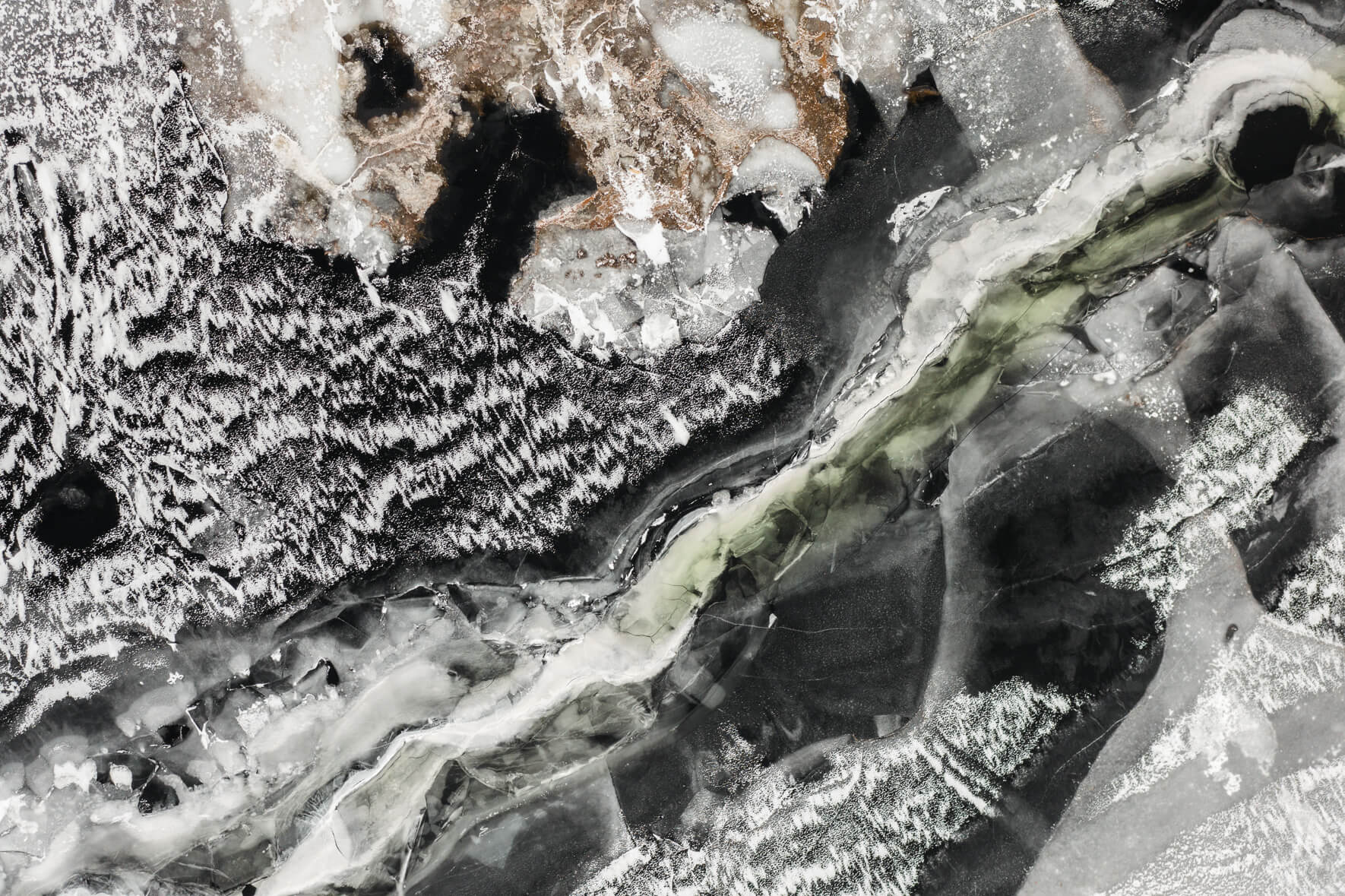 Frozen lake Ã…raksfjorden in Norway from an aerial view with snow and abstract patterns on the ice surface