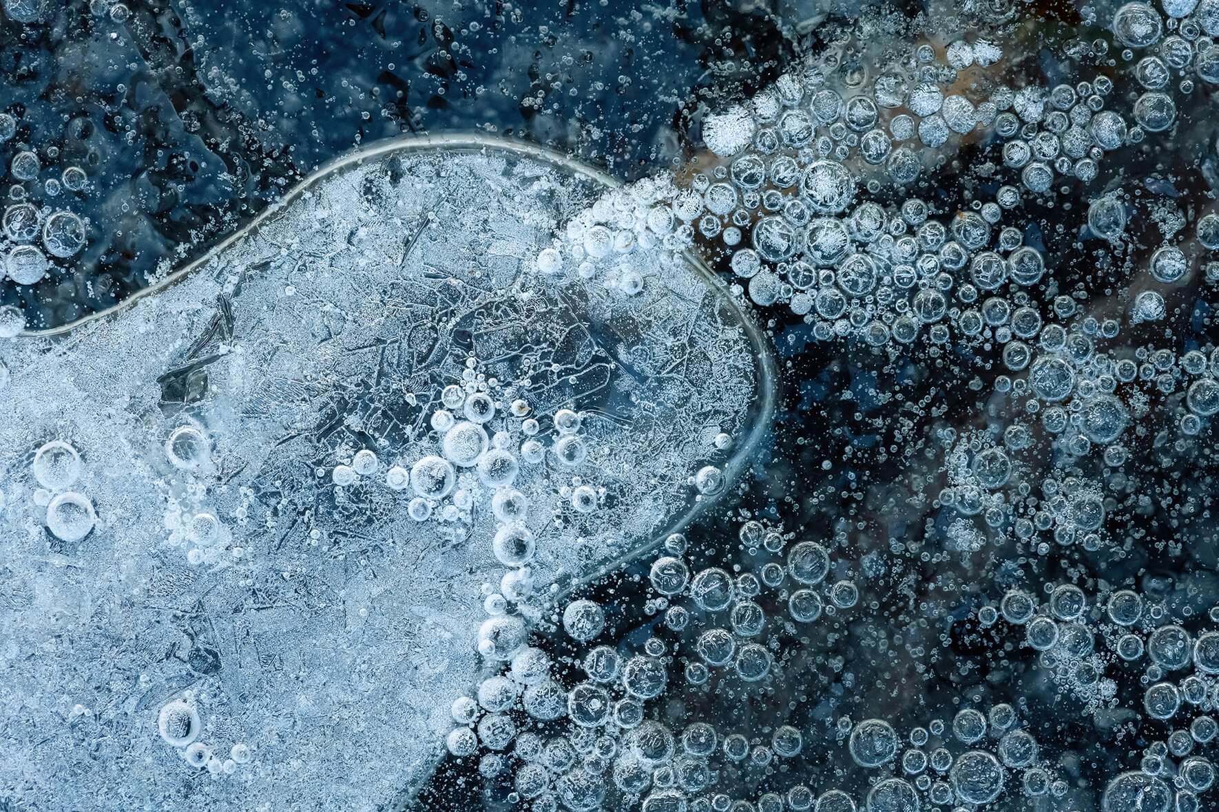 Close up photograph of air bubbles in the ice of a frozen lake in Norway