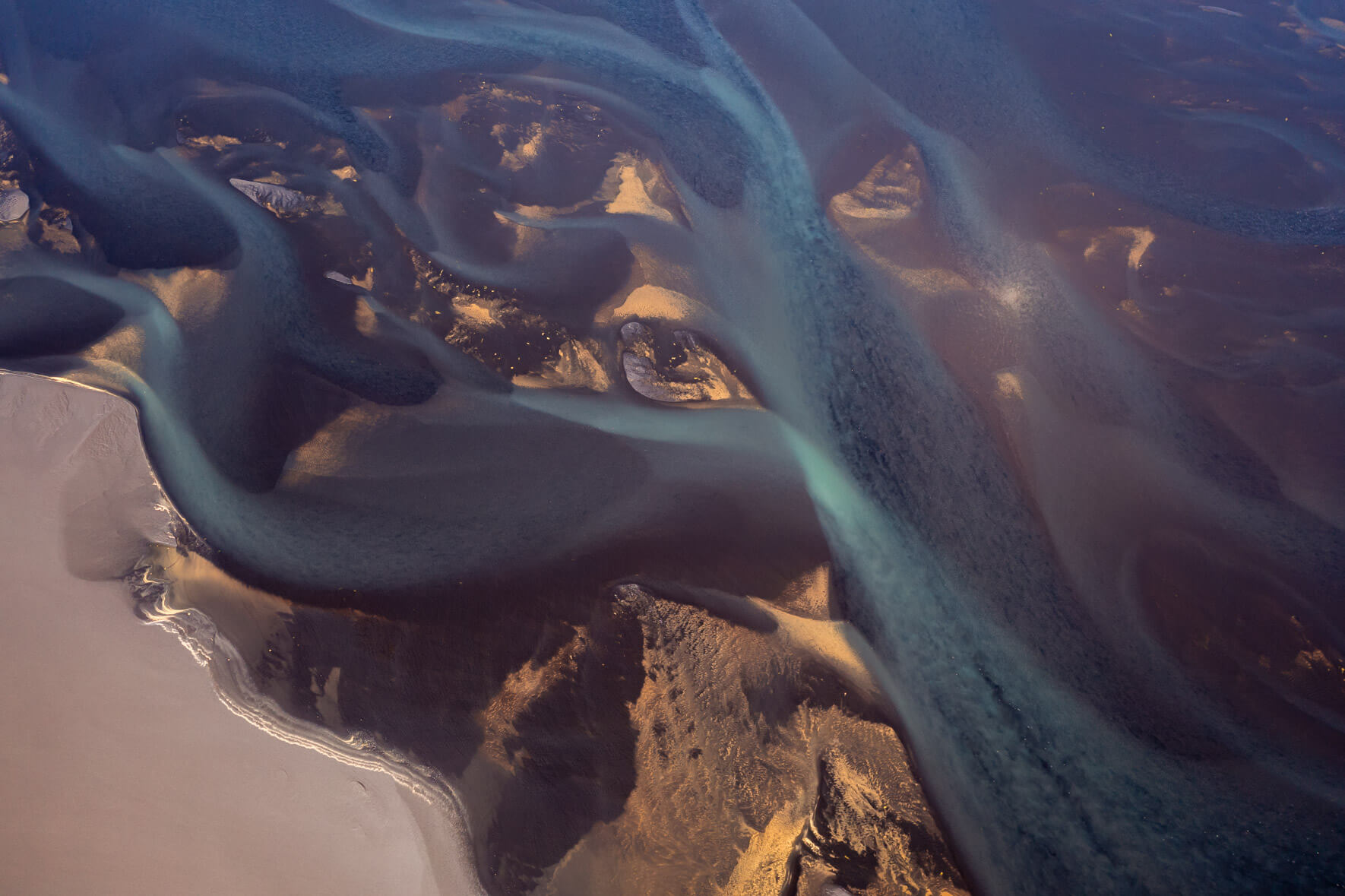 Aerial view of Iceland’s braided glacial rivers, showcasing intricate patterns and sediment-rich waters