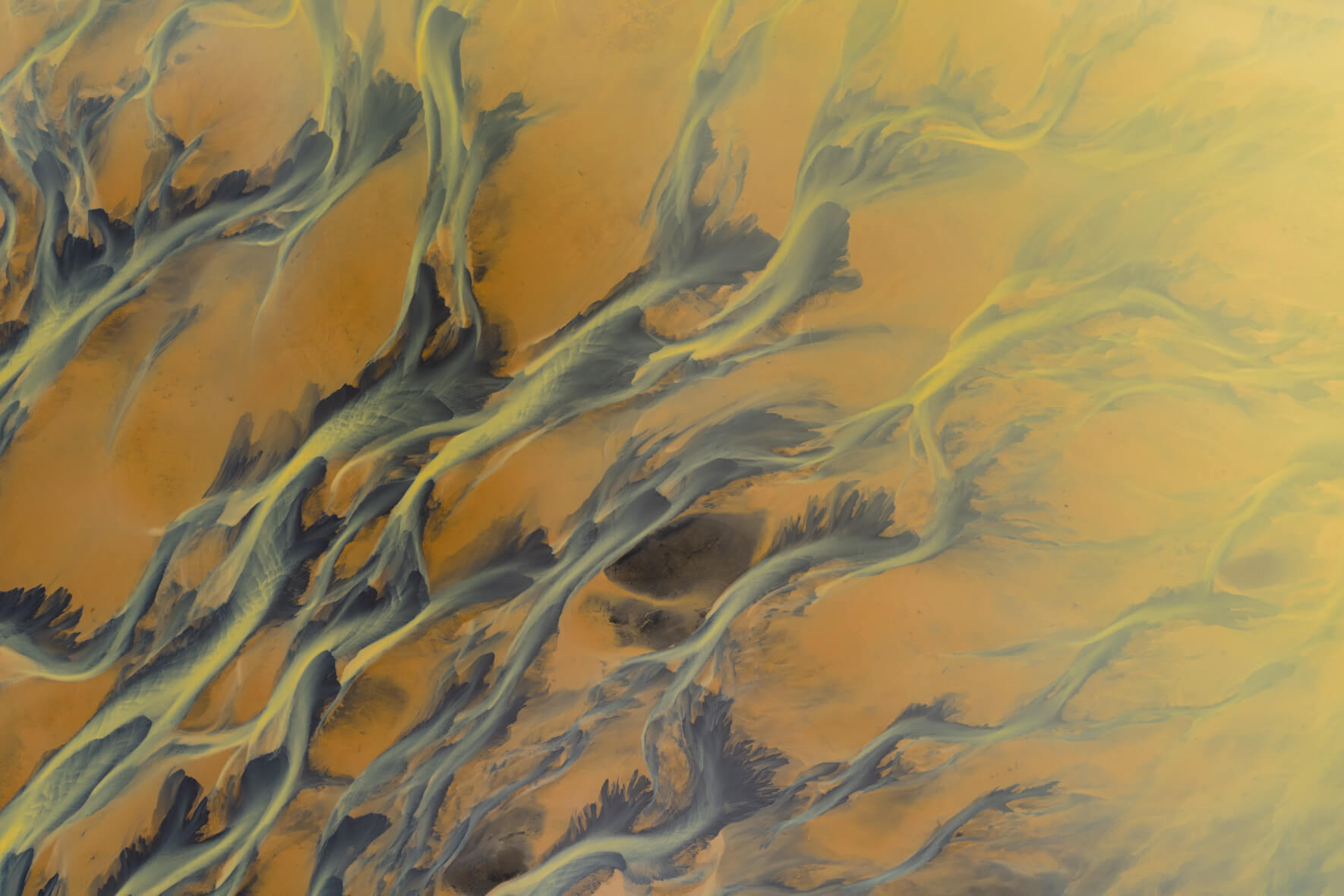 Aerial view of sulphur-rich river delta in Iceland with golden and yellow tones
