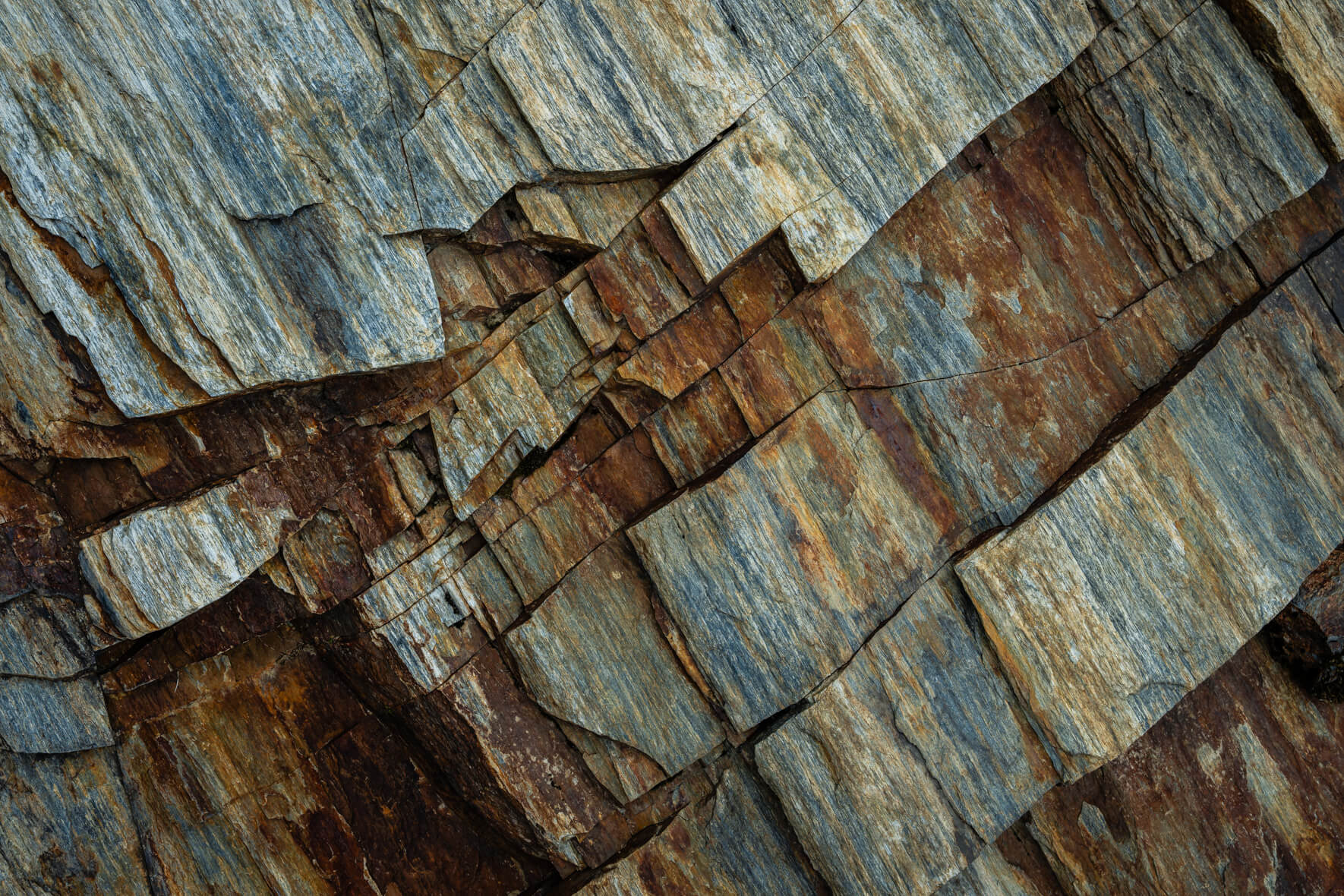 Stratified stone surface with curved layers and traces of mineral oxidation
