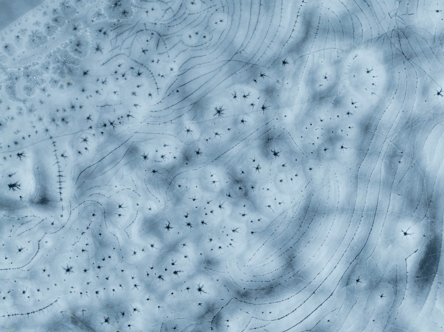 Frozen lake textures shaped by fracture lines and shifting temperatures in Norway