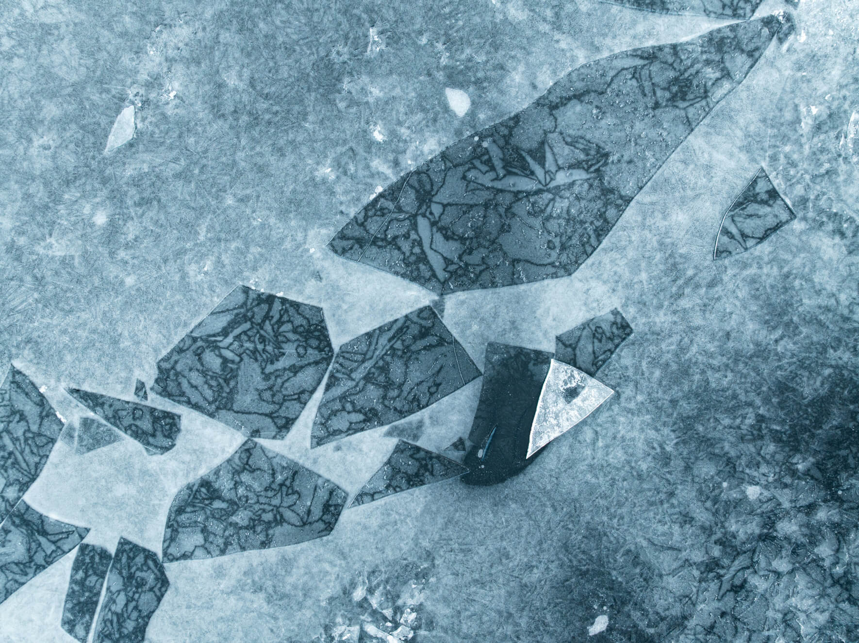 Winter fracture line filled with crushed ice fragments on a frozen surface