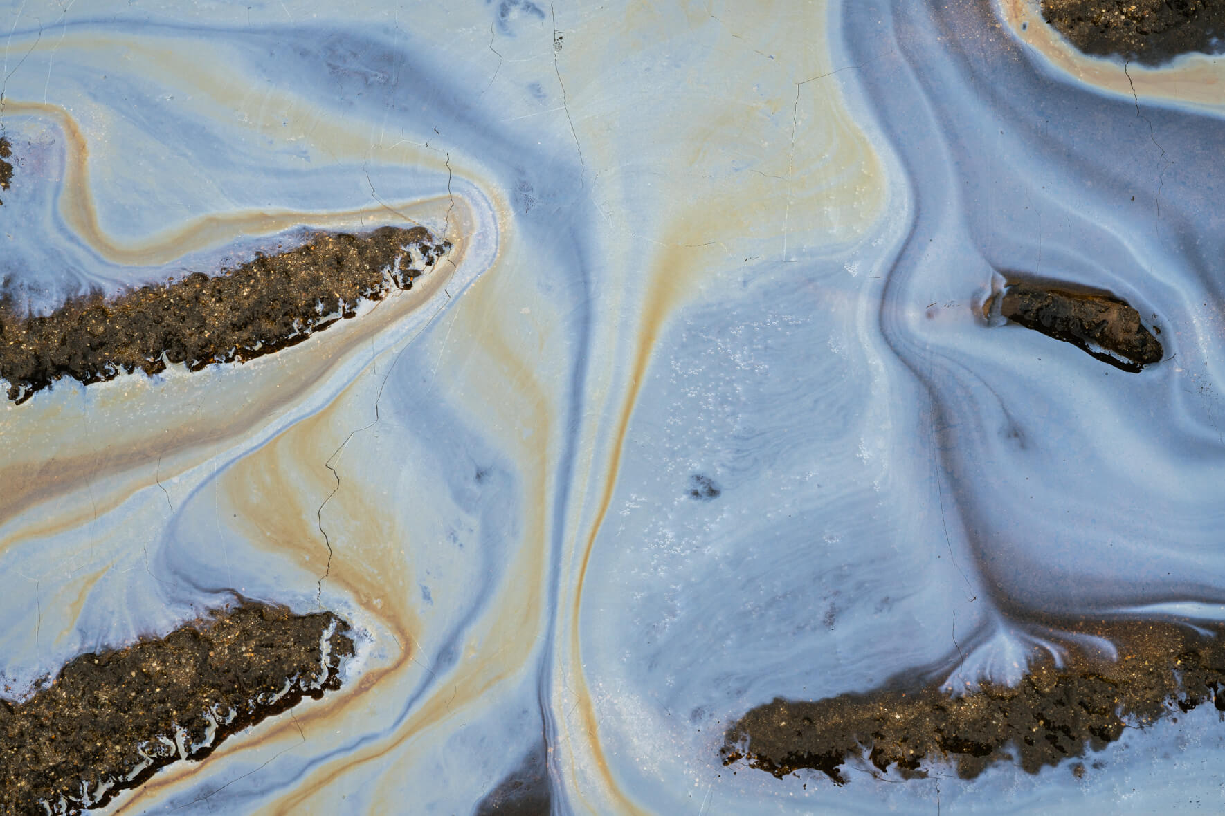 Close-up of oxidized pool surface with metallic and earthy color gradients