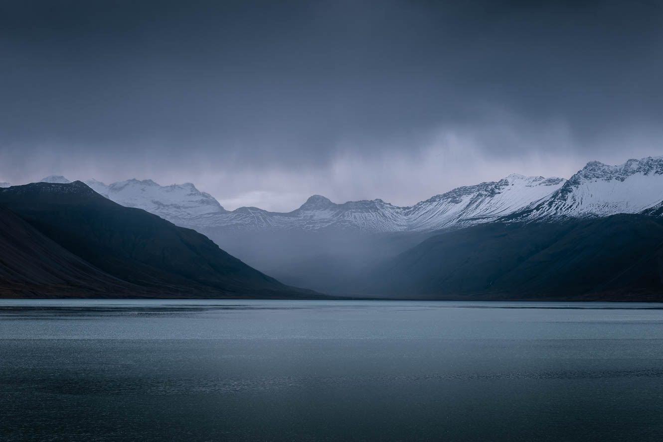 Dark clouds over mountain and fjord landscape in Iceland