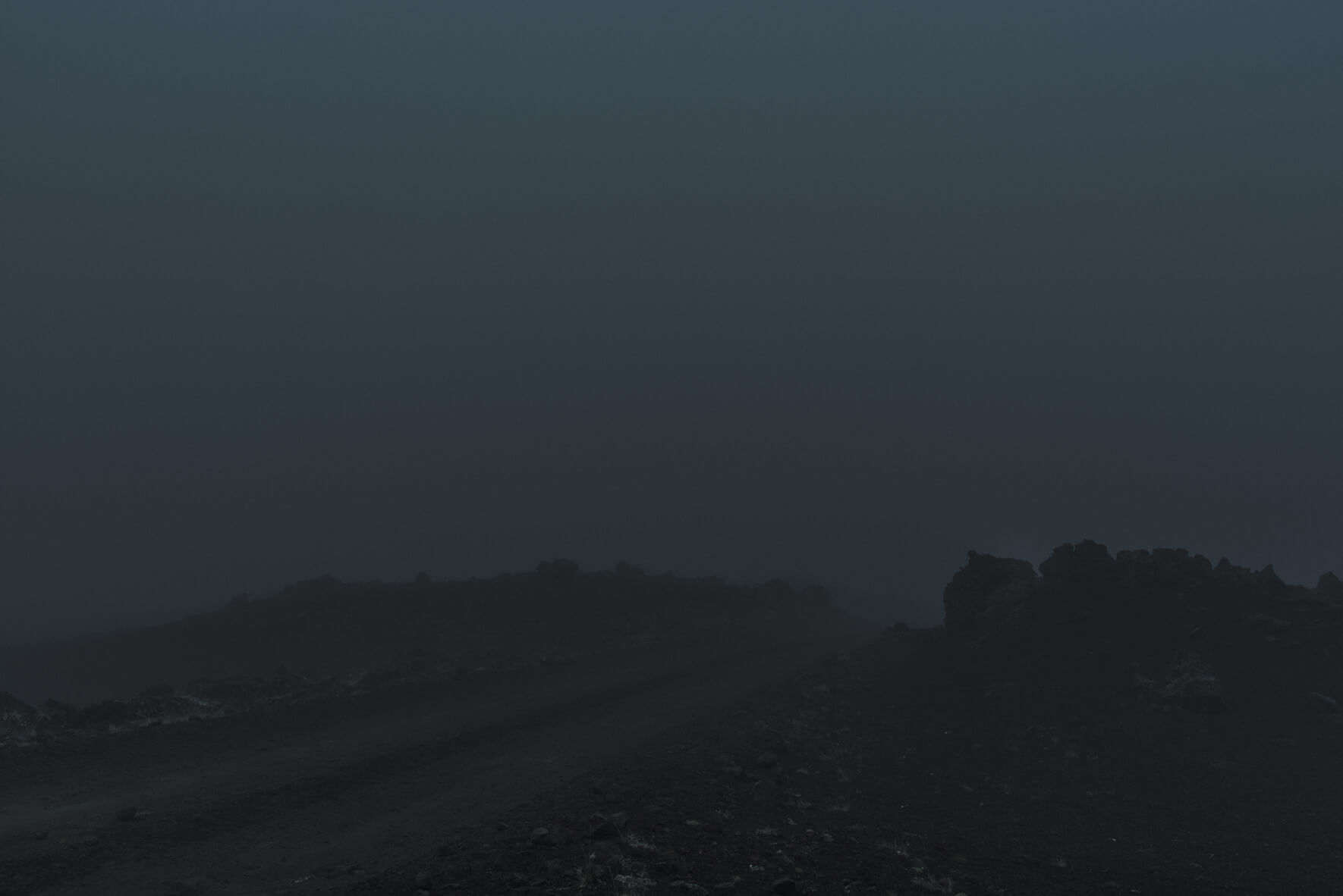 Road and dark silhouettes of rocks in the Highlands of Iceland