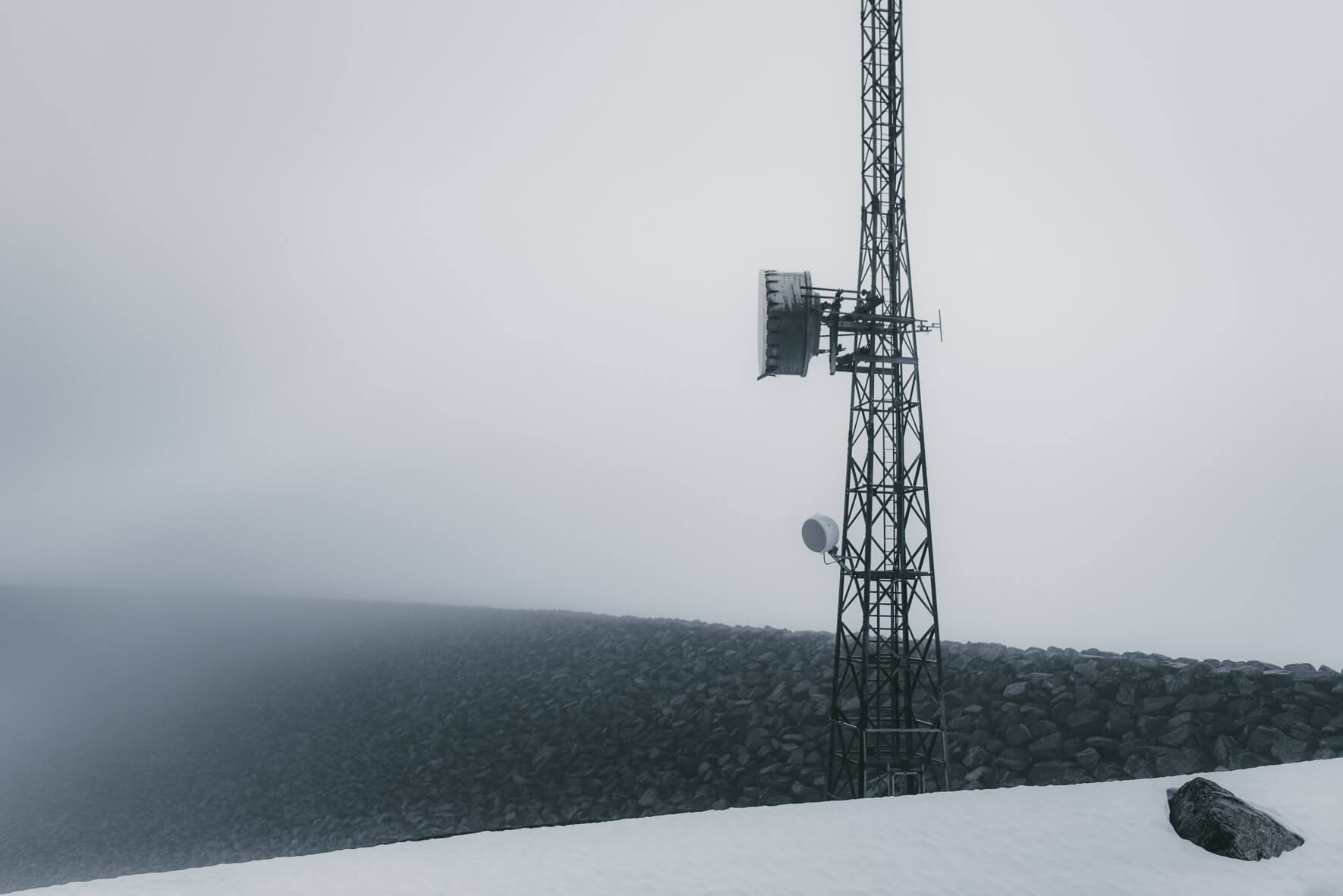Radio antenna and foggy weather at the dam of lake Styggevatnet in Norway