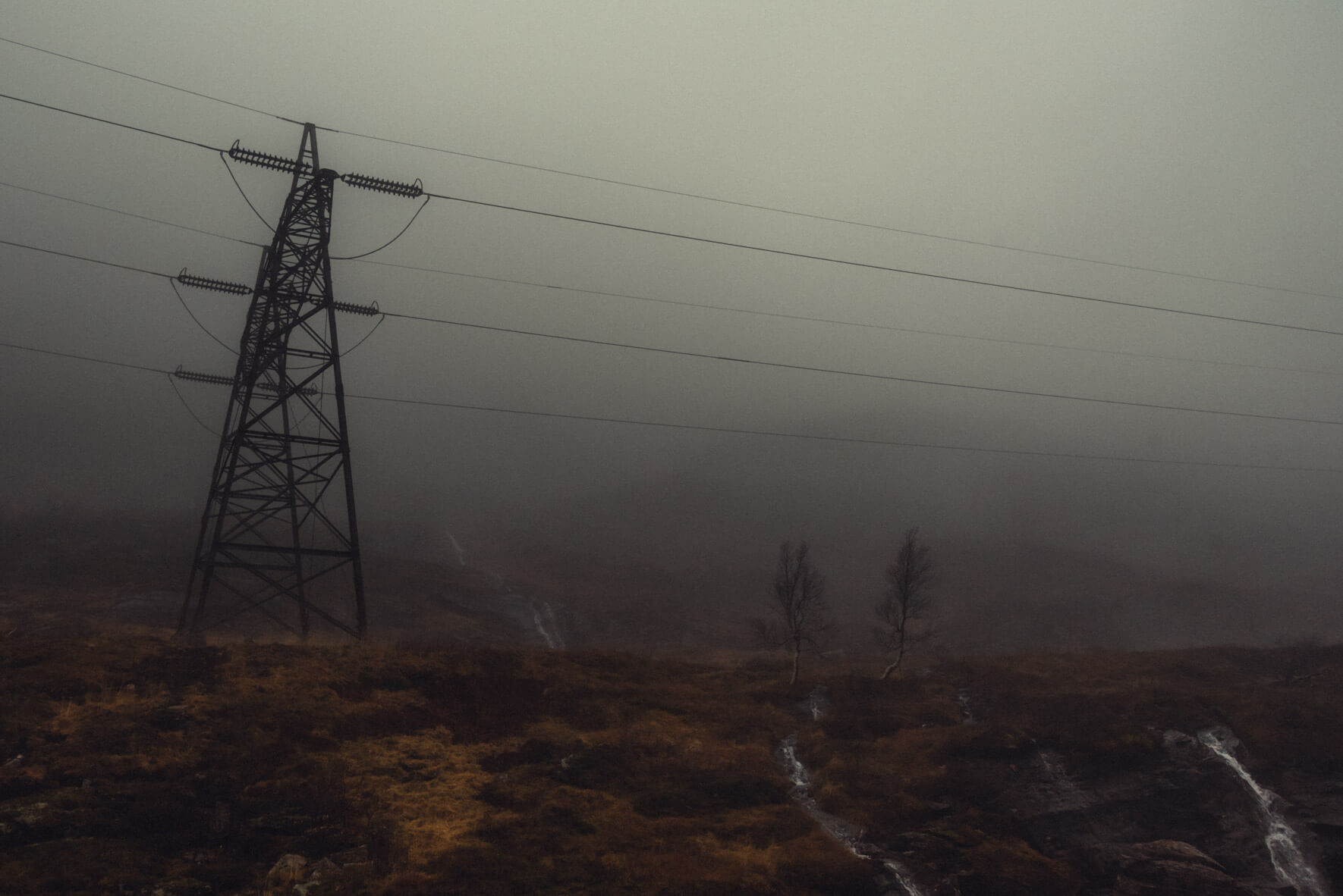 Power line and small creek in the foggy mountains
