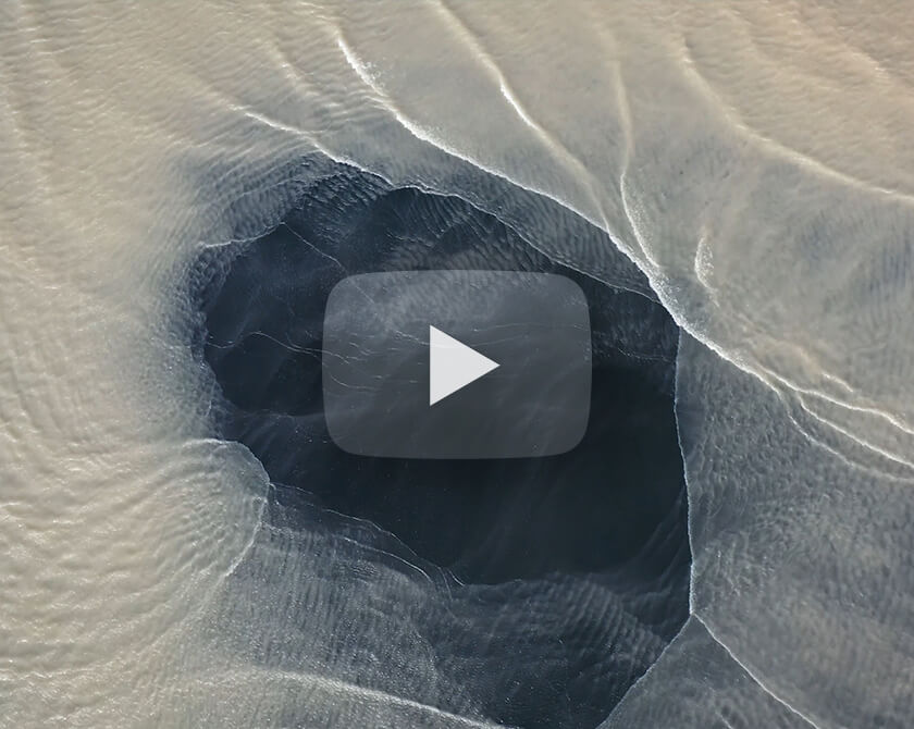 Video of waves washing away a sand island on the coast of Iceland
